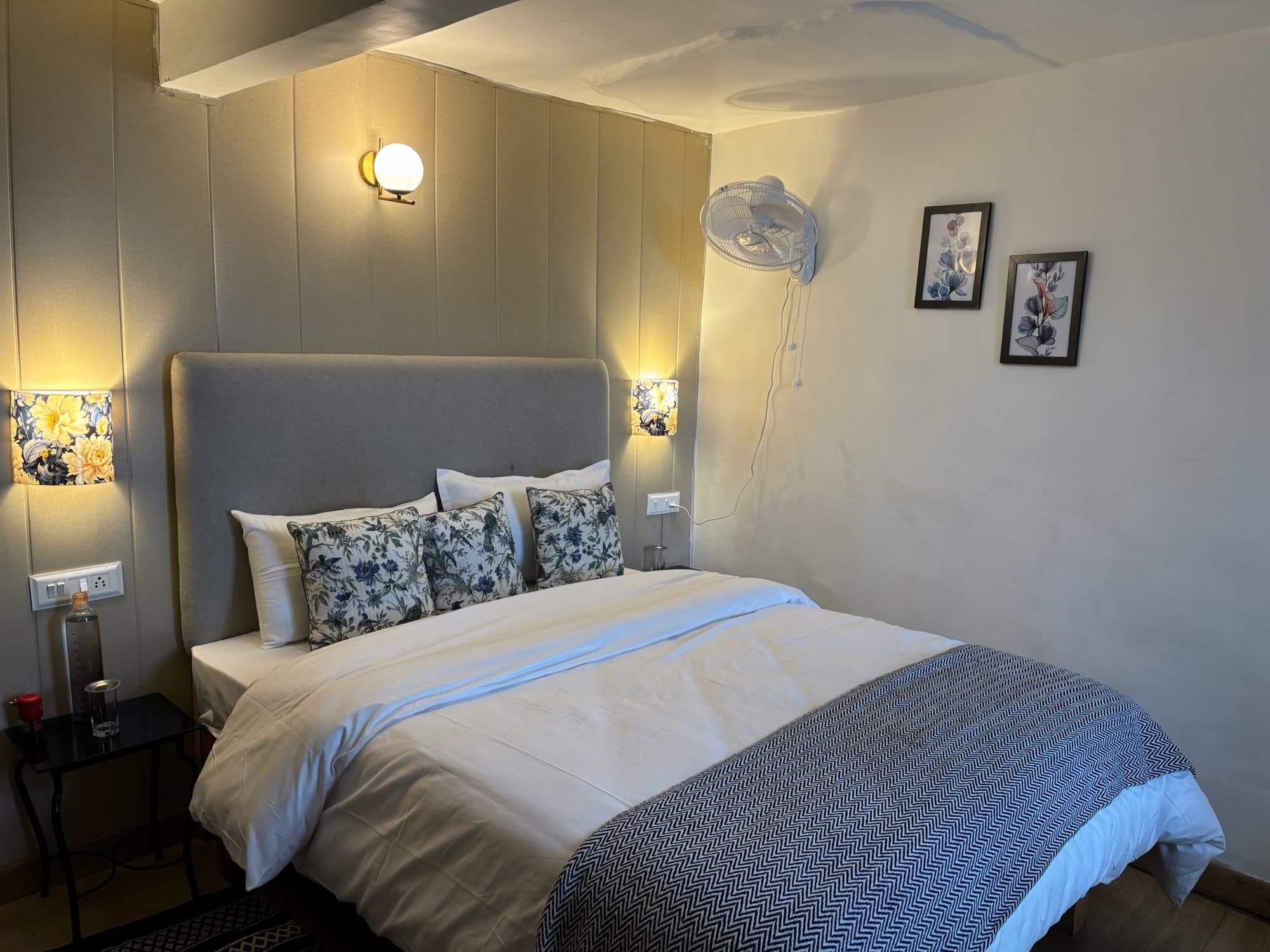 A bedroom at Shail Shikhar with a blue throw and a window to the deodar