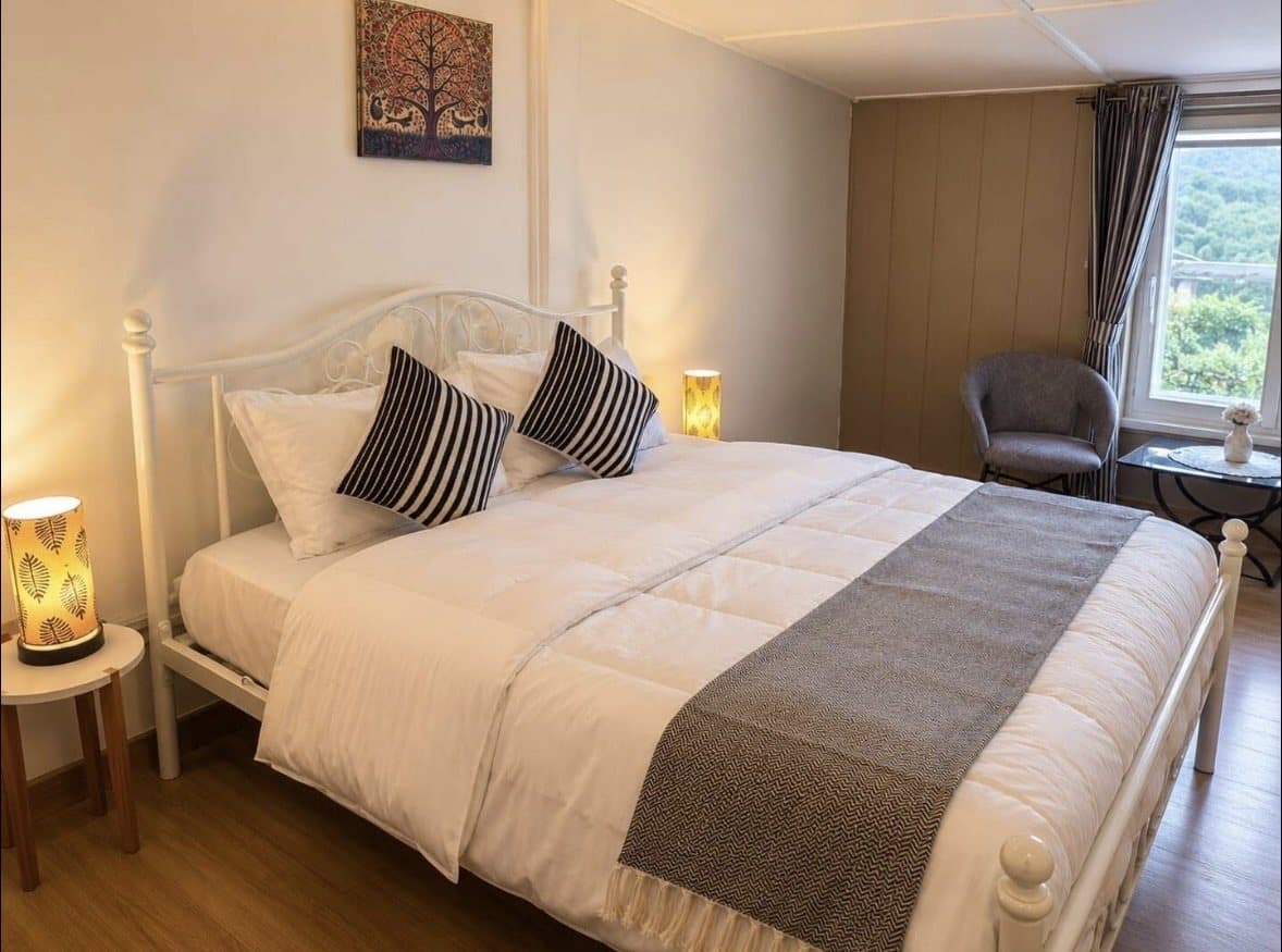 A bedroom at Shail Shikhar in grey and white