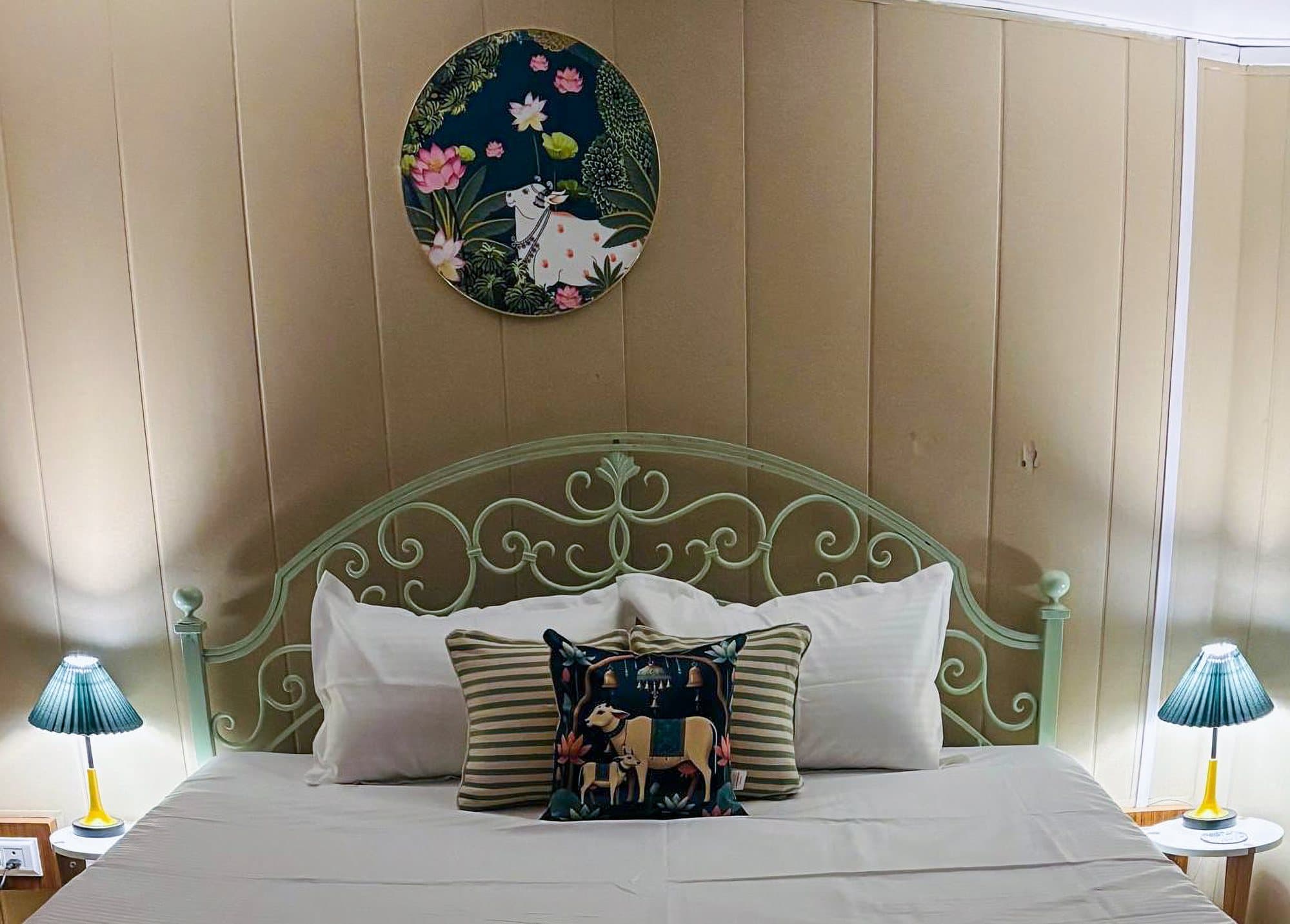 A bedroom at Shail Shikhar with a mint iron headboard